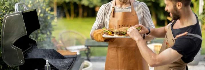 Zwei Personen beim Grillen im Garten